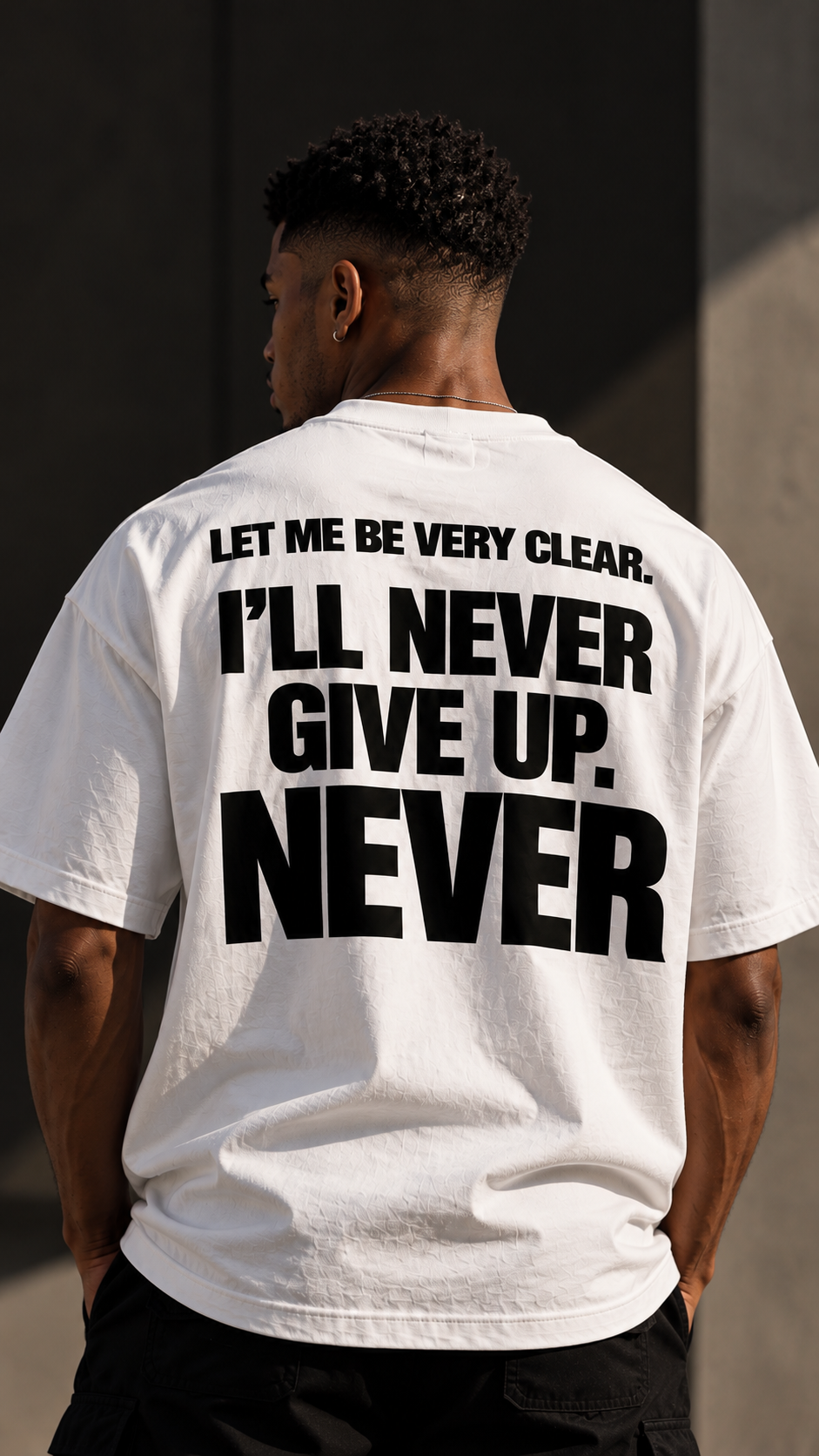Maglietta boxy heavyweight Never Give Up GREATNESS indossata, foto editoriale