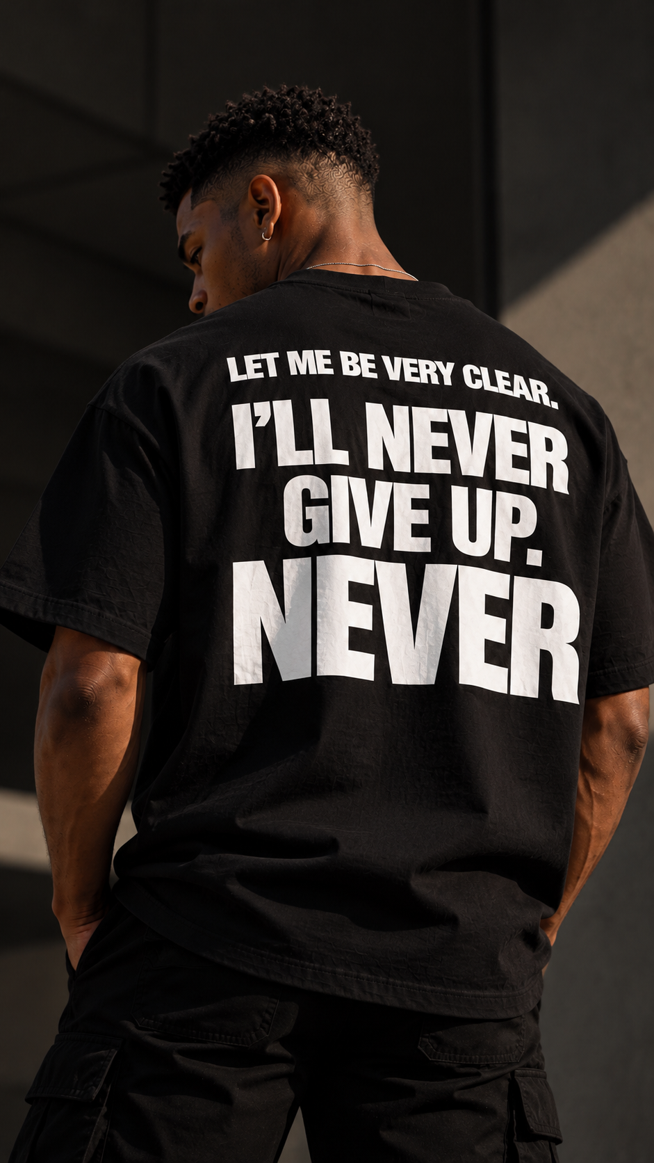 Maglietta boxy Never Give Up GREATNESS indossata, foto editoriale
