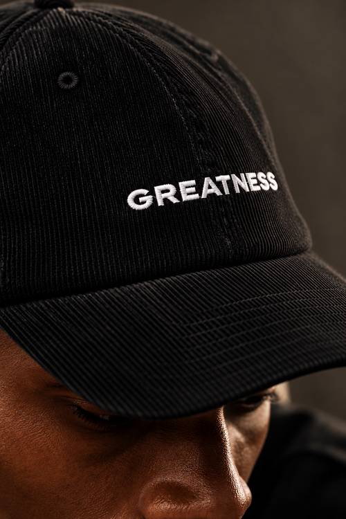 Cappellino in velluto a coste GREATNESS in nero, dettaglio ravvicinato del logo